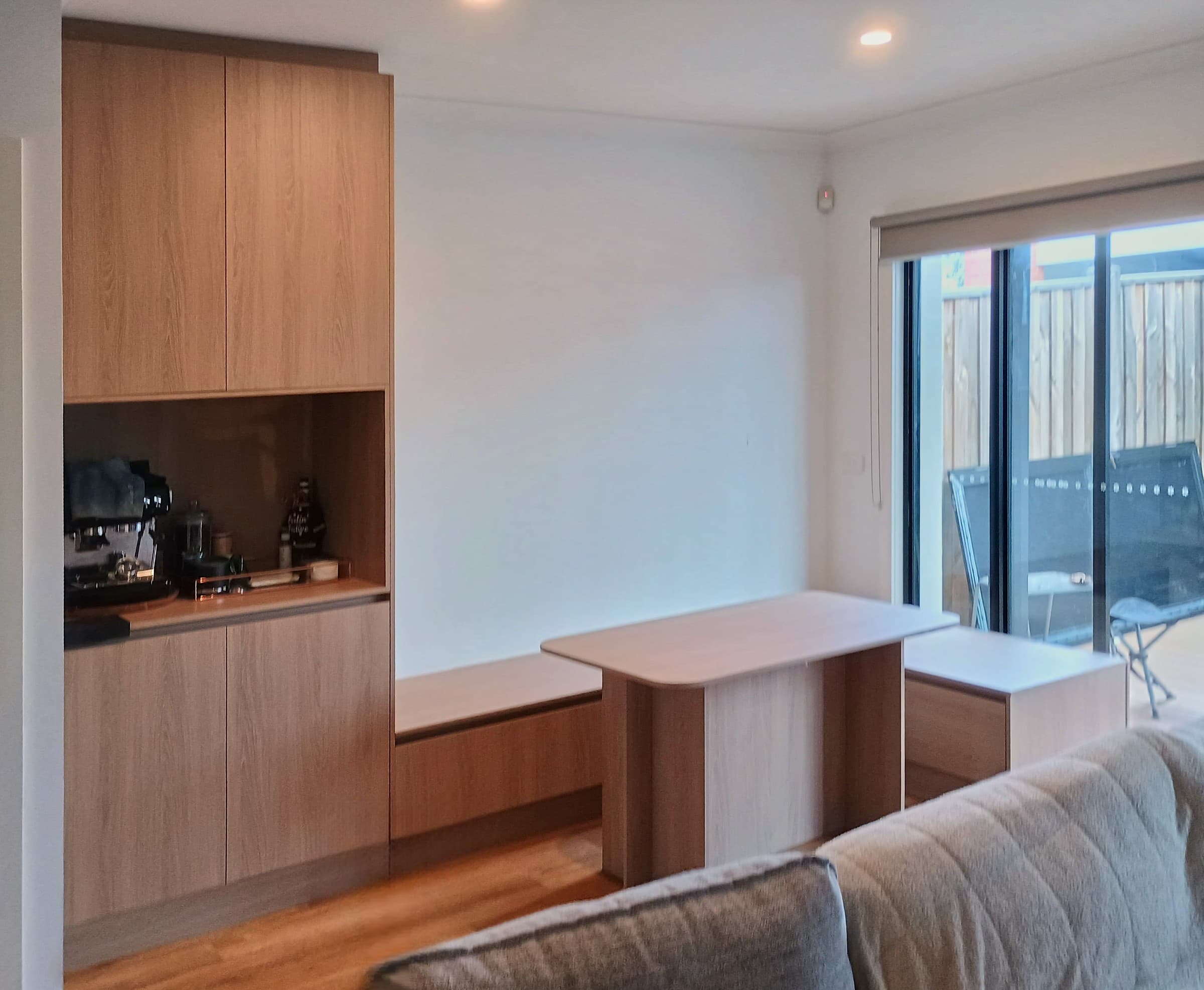 Coffee bar & dining nook: floor-to-ceiling light oak-look cabinetry with open appliance niche and matching built-in bench seating.